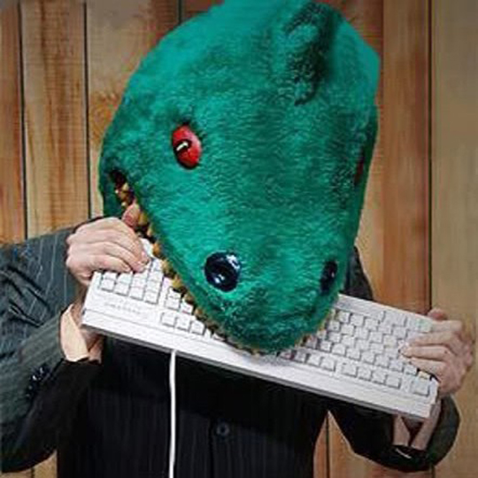A logo that I use on the web. A green, red eyed, dinosaur chewing a keyboard in wooden background